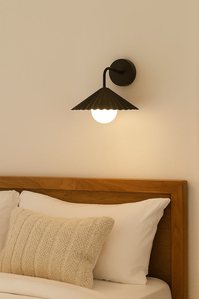 Bedroom setting with a wooden headboard, pillows, and a wall-mounted lamp.