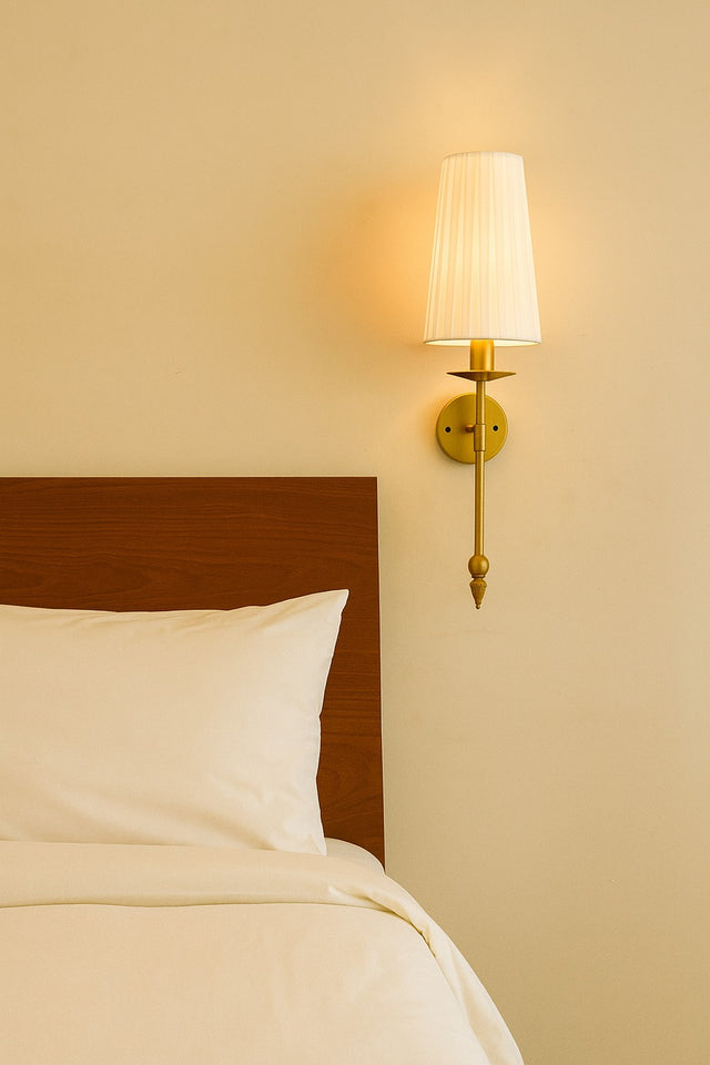 Bedroom with a wooden headboard and a wall-mounted lamp on a beige wall.