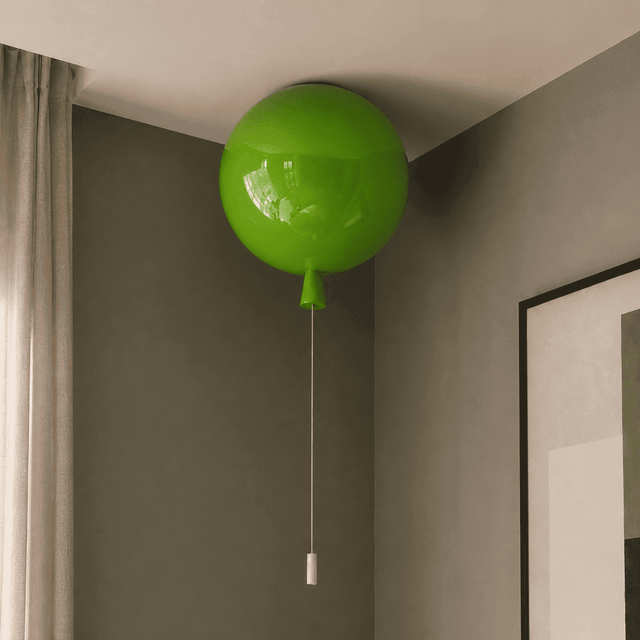 A bright green balloon-shaped ceiling light fixture with a pull chain, shown installed in the corner of a room with gray walls and a white ceiling.