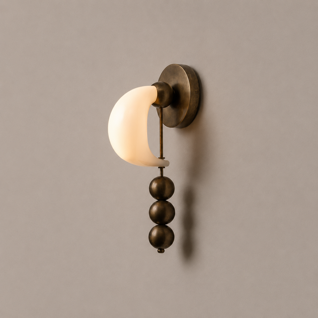Wall-mounted light fixture with a beige shade and bronze accents on a plain wall.