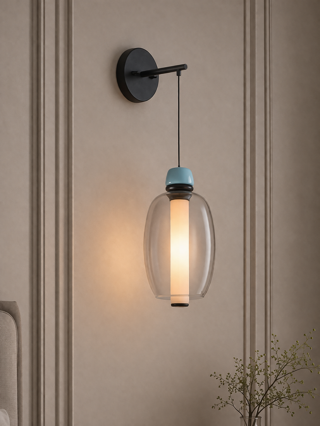 Wall-mounted light fixture with glass shade on a neutral wall.
