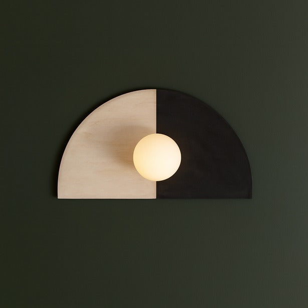 Wall lamp with a half-circle design on a dark green background