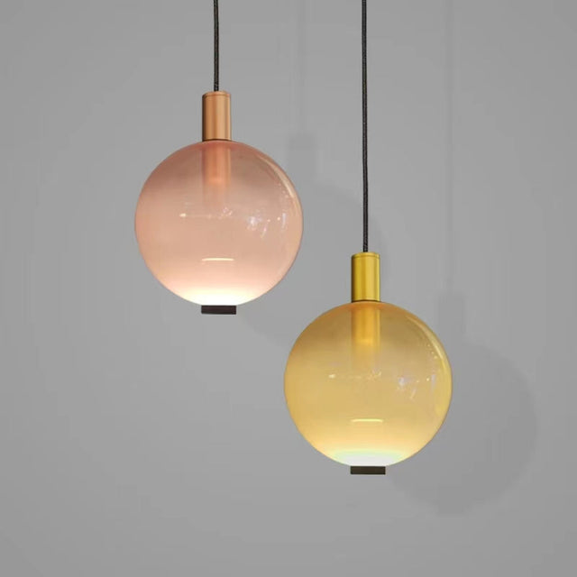 Two pendant lights with pink and yellow glass globes on a gray background