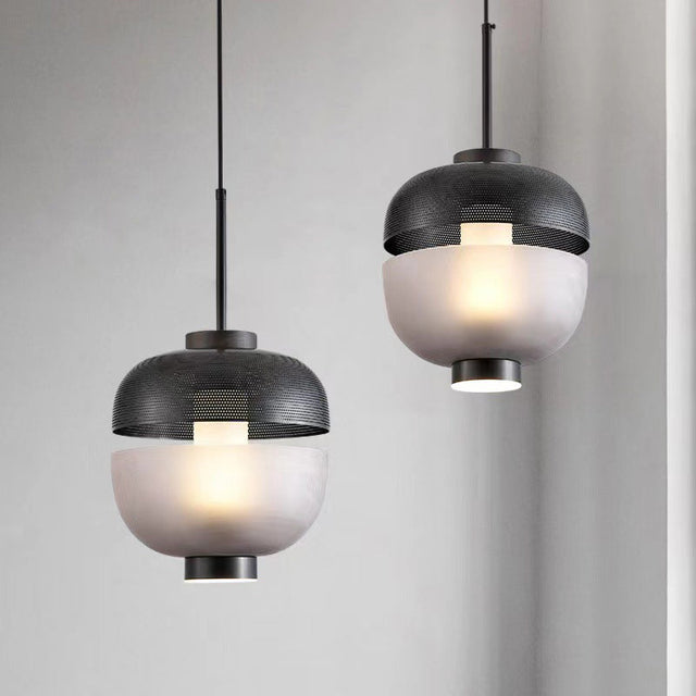 Two modern pendant lights with glass shades on a neutral background
