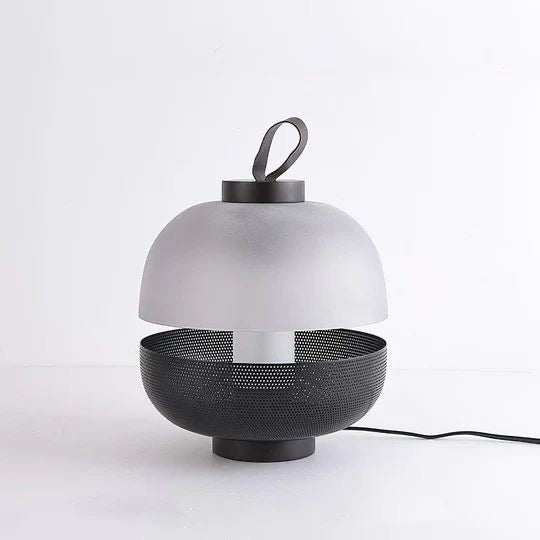 Modern table lamp with white shade and black base on a white background
