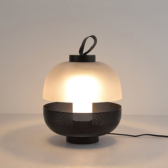 Modern table lamp with a mesh base and white shade on a neutral background