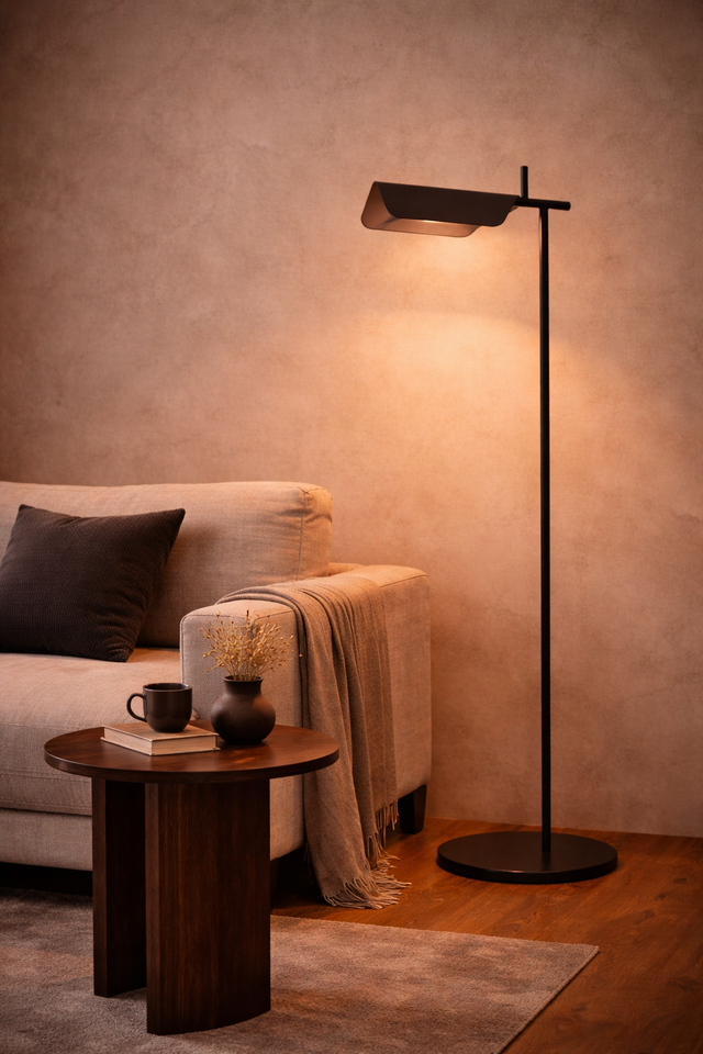 Modern floor lamp in a living room setting with a sofa and side table.