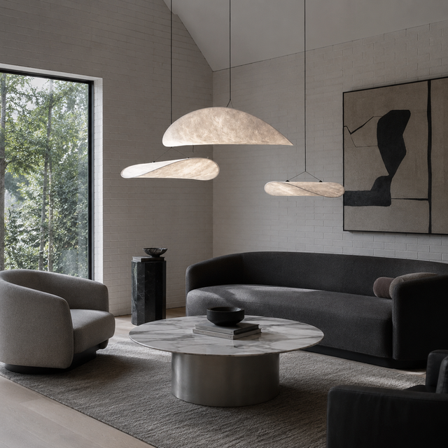 Modern living room with gray sofa, armchairs, and pendant lights.