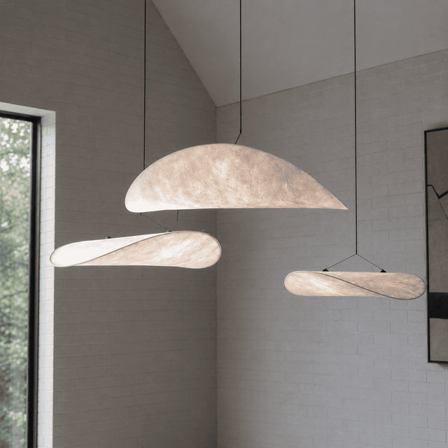 Modern pendant lights hanging in a room with a neutral color palette.