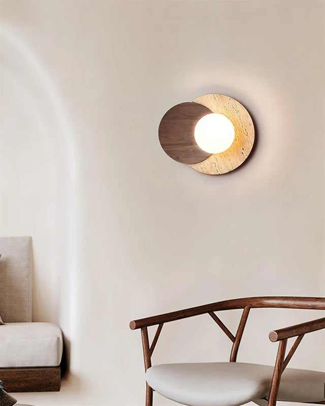 Modern wall light fixture in a minimalistic room with a chair and sofa.