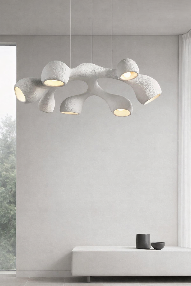 Modern pendant light fixture hanging in a room with a neutral color palette.