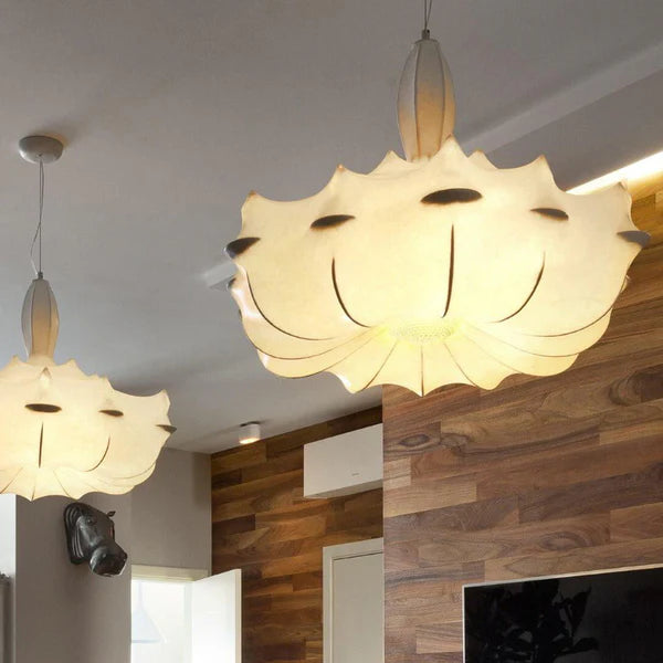 Two modern pendant lights hanging in a room with wooden walls.