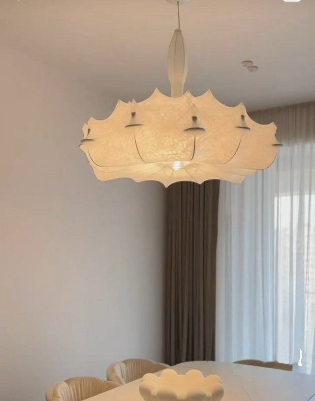 Chandelier hanging above a dining table with curtains in the background