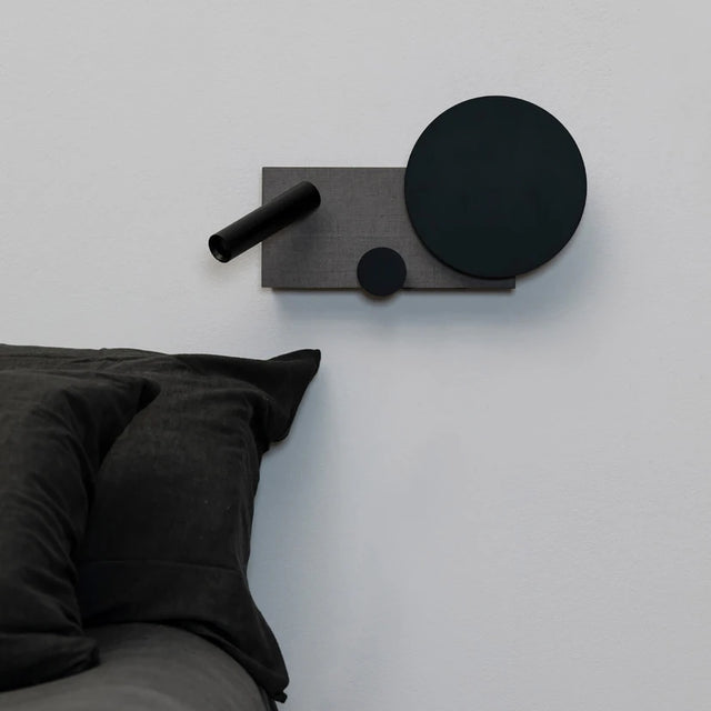 Modern wall-mounted coat rack with black and gray design on a white wall.