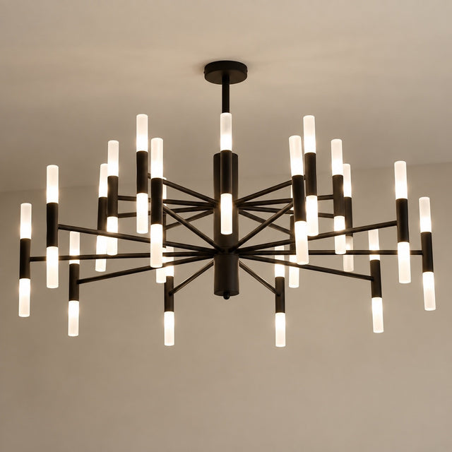 A modern multi-light chandelier with a black metal frame and cylindrical frosted glass shades, suspended from a ceiling against a plain light gray wall.