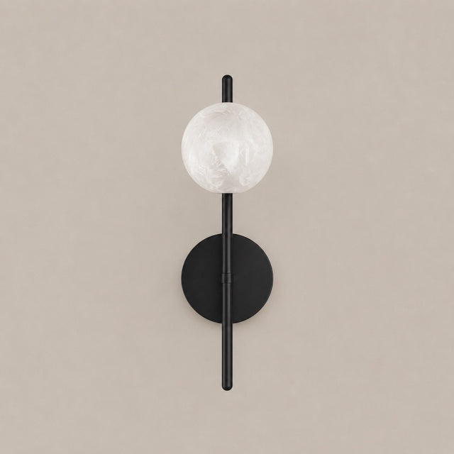 A modern wall sconce light fixture with a matte black metal frame, featuring a round textured white glass globe shade and a circular black wall mount, shown against a solid beige background.
