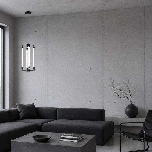 A modern minimalist living room featuring a dark charcoal sectional sofa, a matching square coffee table, a black pendant light with vertical glass tubes, and a black chair against a concrete wall.