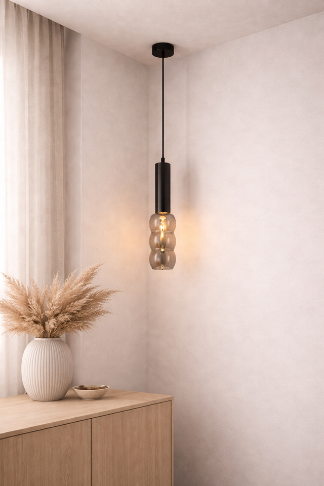 Modern pendant light hanging in a room with a wooden cabinet and decorative items.