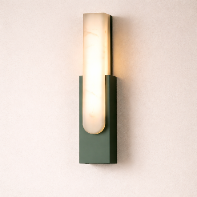 Wall-mounted light fixture with a green base and white glass shade on a beige wall.