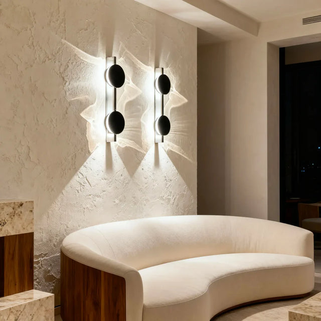 Modern interior with a curved white sofa and wall-mounted lights.