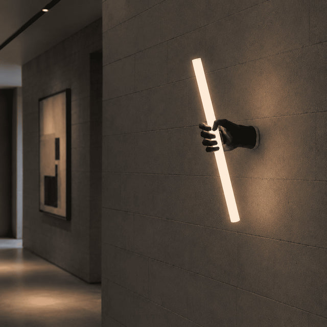 Modern wall light fixture on a textured wall in a dimly lit room.