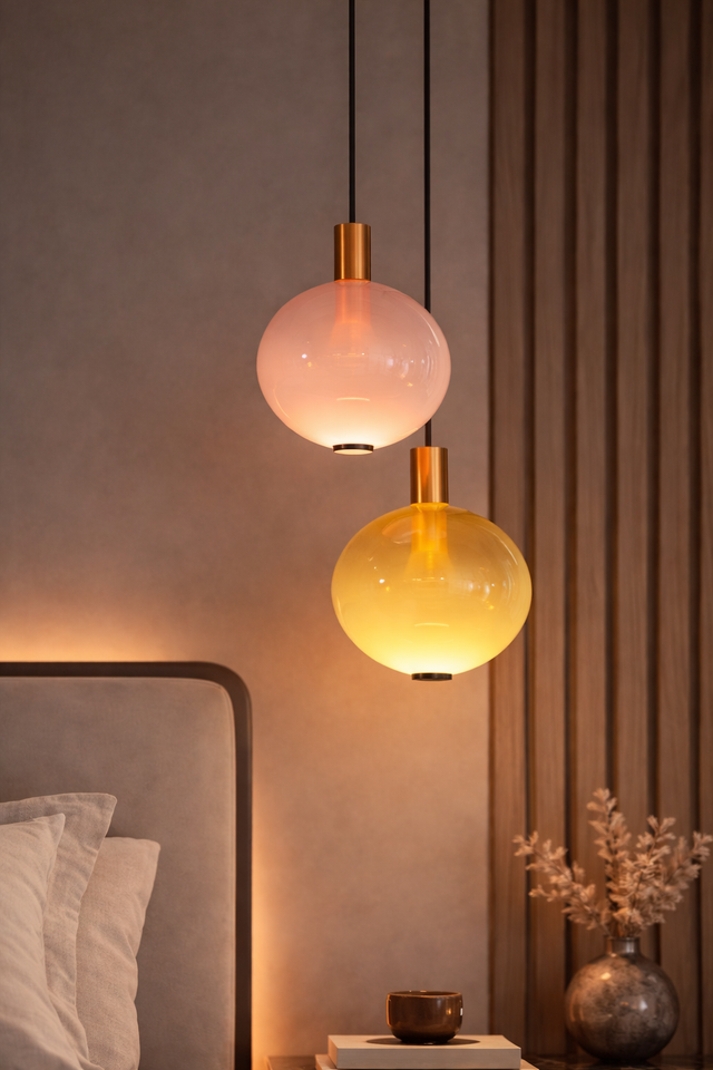 Two pendant lights hanging above a bed with a warm glow.