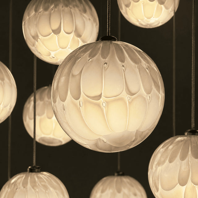 Close-up of spherical glass light fixtures with a warm glow on a dark background