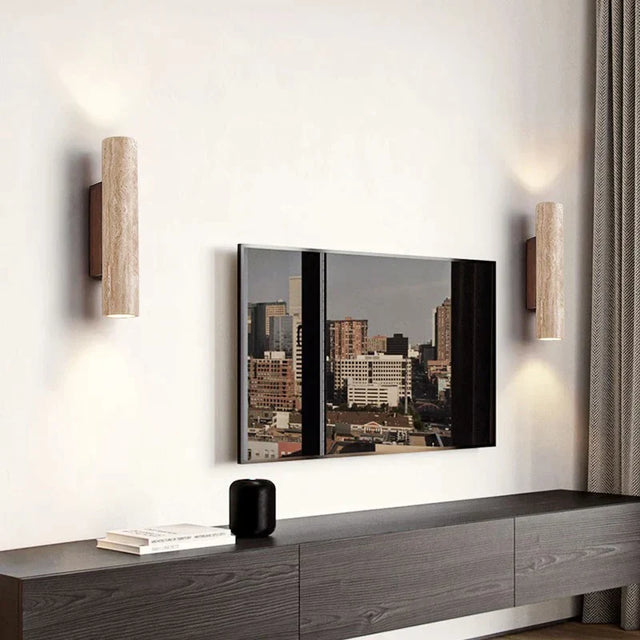 Modern living room with a TV mounted on the wall, wooden sideboard, and decorative sconces.