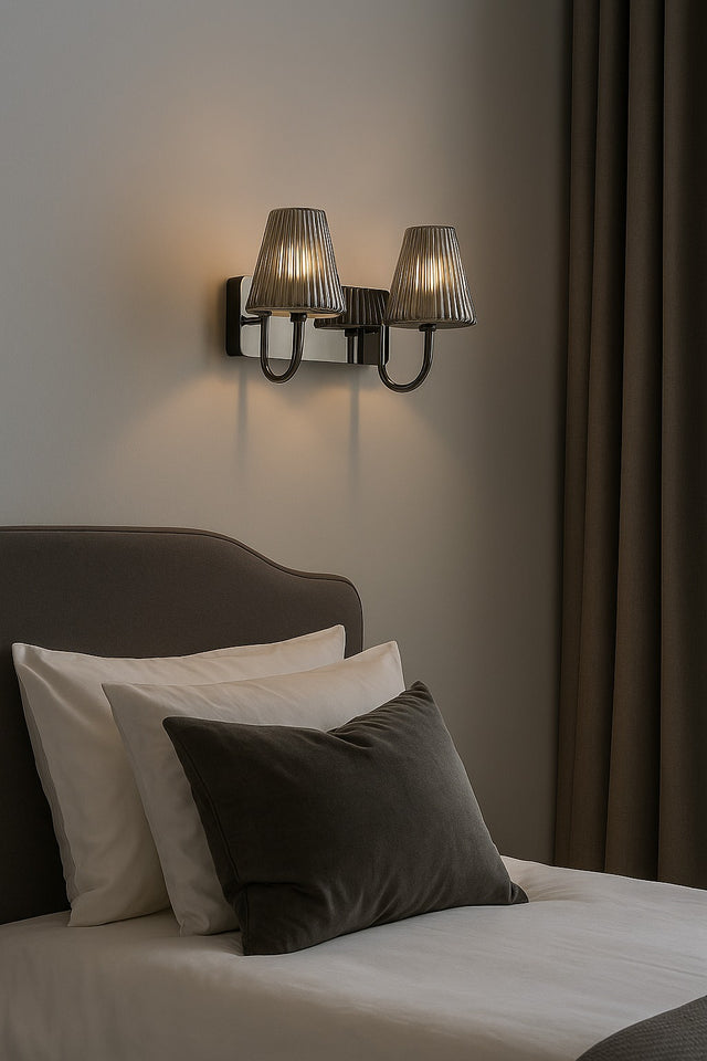 Bedroom with pillows on a bed and wall sconces.