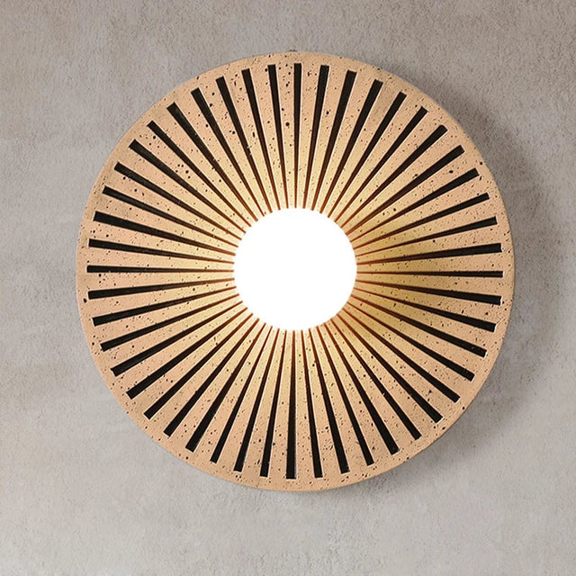 Round wooden coaster with sunburst pattern on a gray background