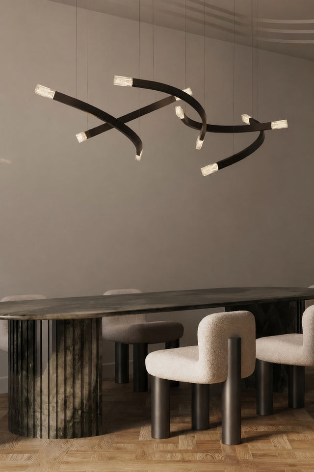 A modern multi-arm black pendant chandelier with white-tipped lights hanging above a dark wood dining table and upholstered dining chairs in a minimalist dining room.